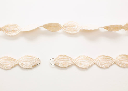 Plan view of a woven ivory white cotton ovals necklace with Sterling Silver looped ends a white background