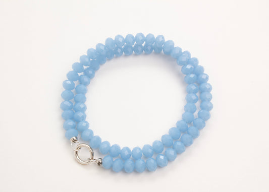 Plan_view of a Light_blue_rondelles_glass_bead_strand_wrapped_in_two_loops_on a white background.