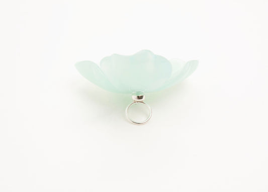 Full back close up of a mint green resin_flower charm with a Sterling Silver looped ending on a white background