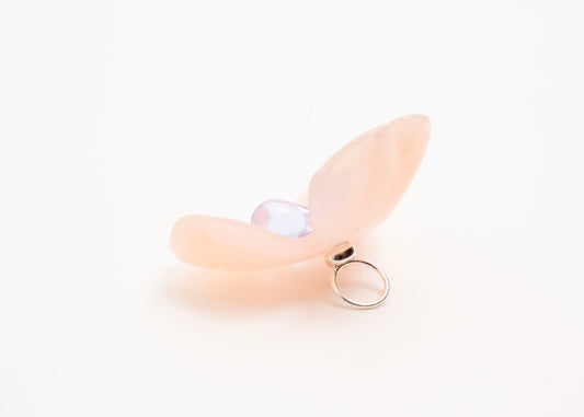 Side back close up of a peach resin_flower charm with lavender glass beads detail_and a Sterling Silver looped ending on a white background.