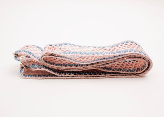 Front side view of a folded cotton fishnet ribbon in pink and light blue with Sterling Silver looped endings on a white background