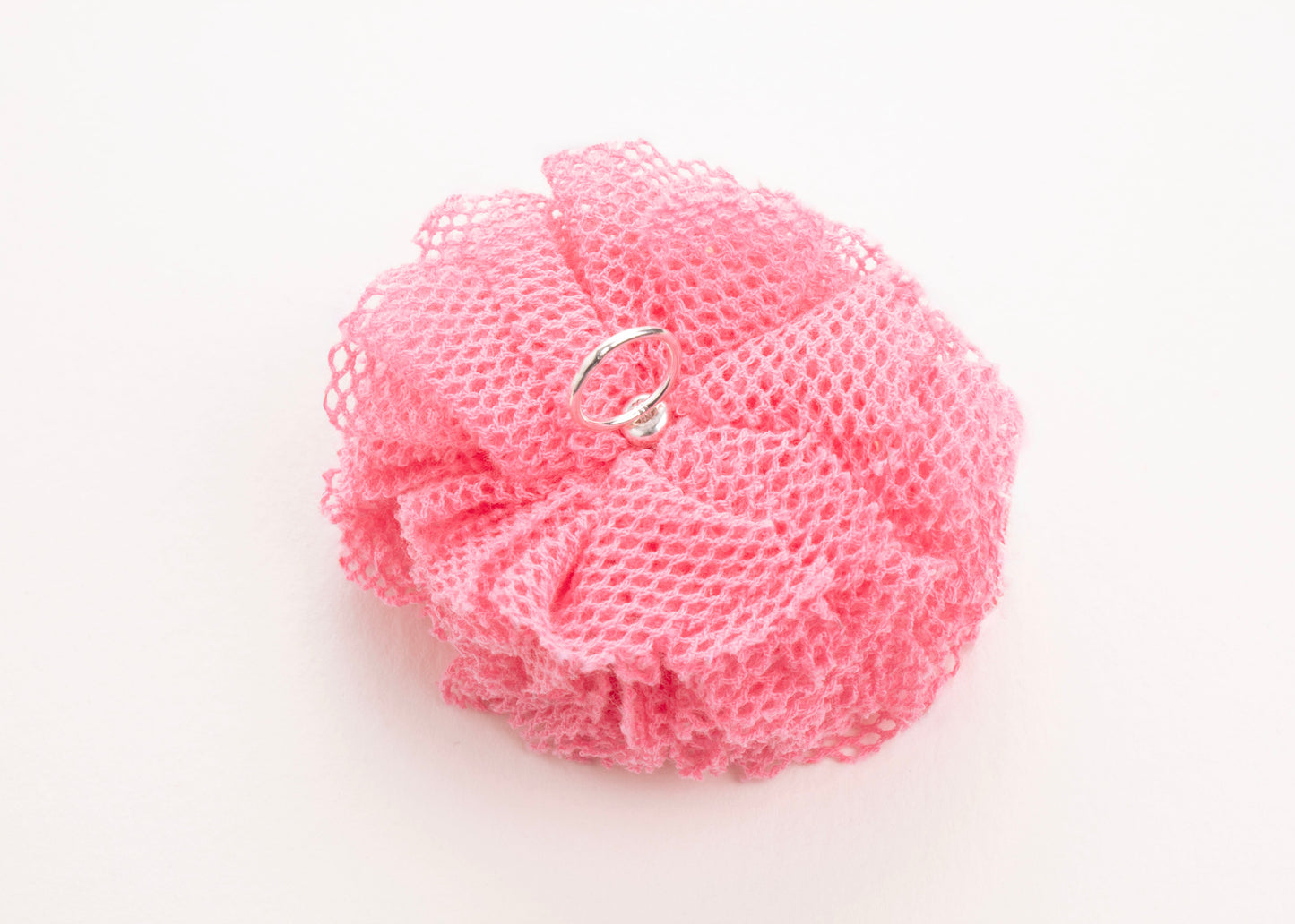 Back view of a rose point de tulle flower charm with Sterling Silver ending on a white background