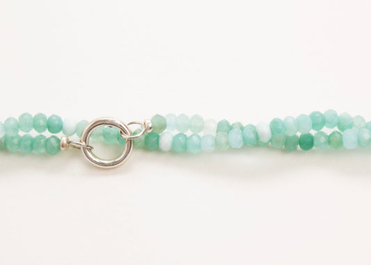 Front horizontal view of the bead detail of a closed turquoise_small_quartzite_beads_strand twisted on a white background
