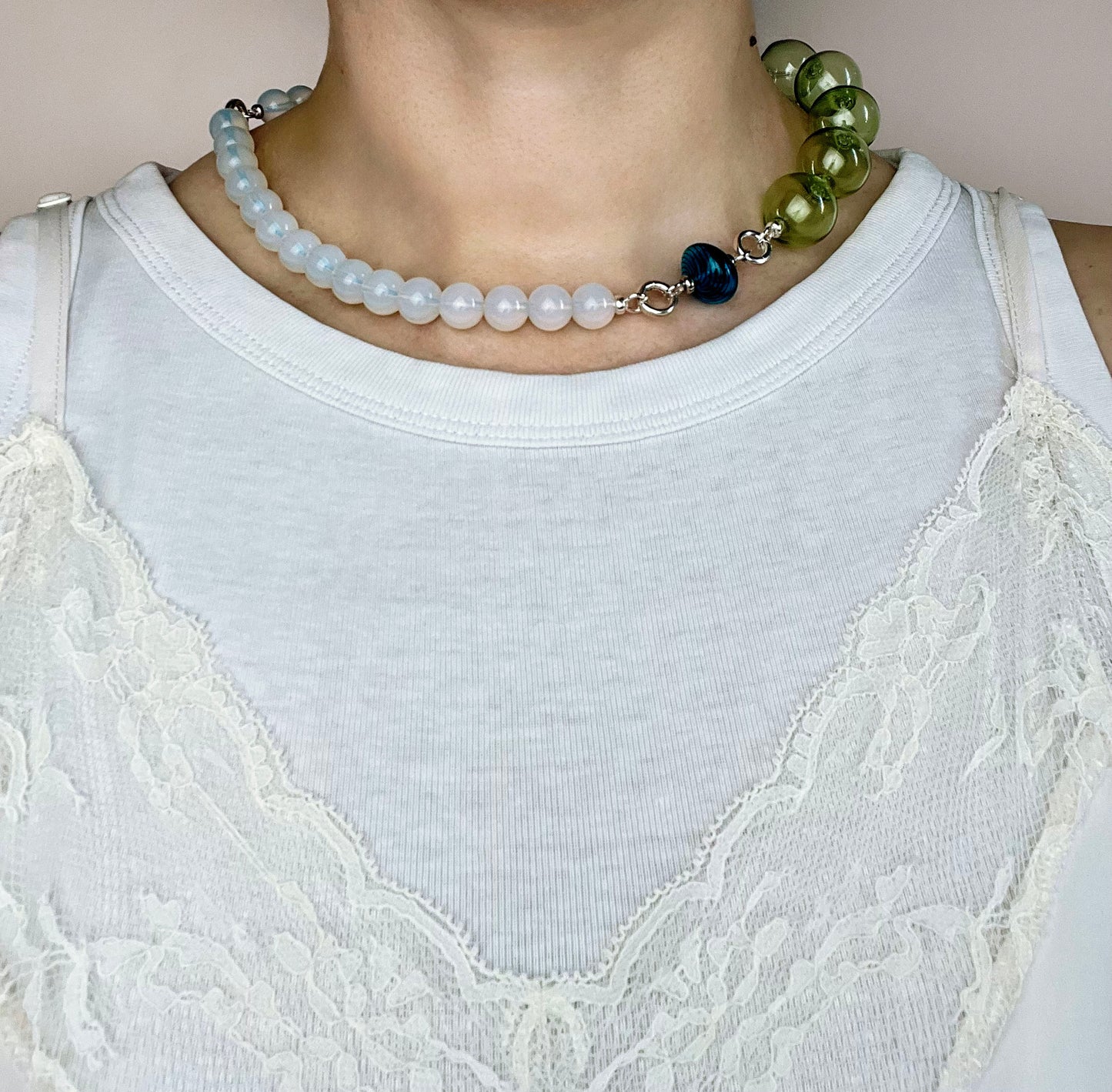 Front view of a ready to wear necklace made with green blue opalite placed on a round neck line with blue glass top charm and pink chunky glass bead chainlet with Sterling Silver endings