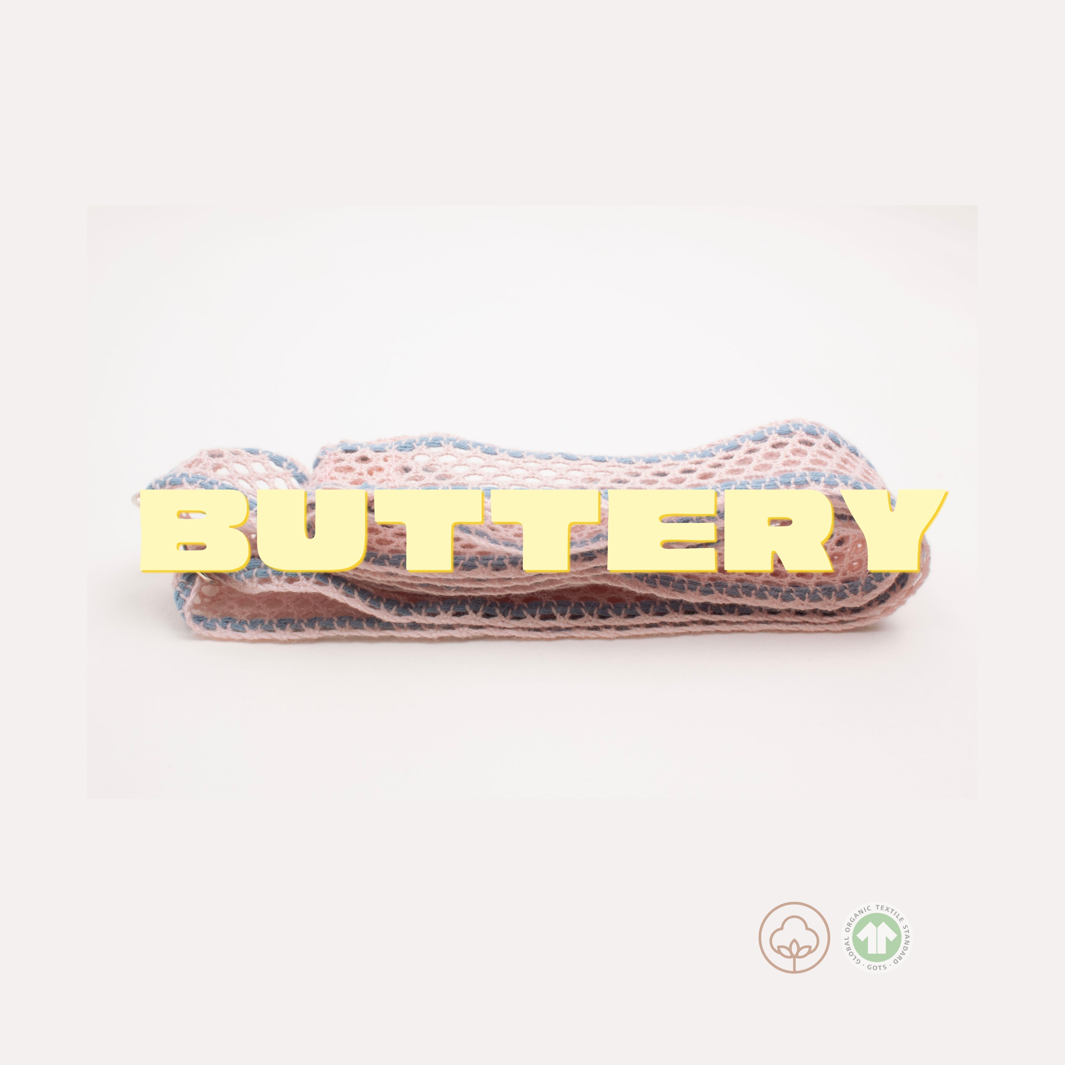 word 'Buttery' in butter yellow chunky fonts placed over a folded Organic Cotton Soft Necklace on a white background
