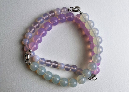 Overhead view of a Opalite beaded necklace made with chainlets with Sterling Silver open loop ends on a white background