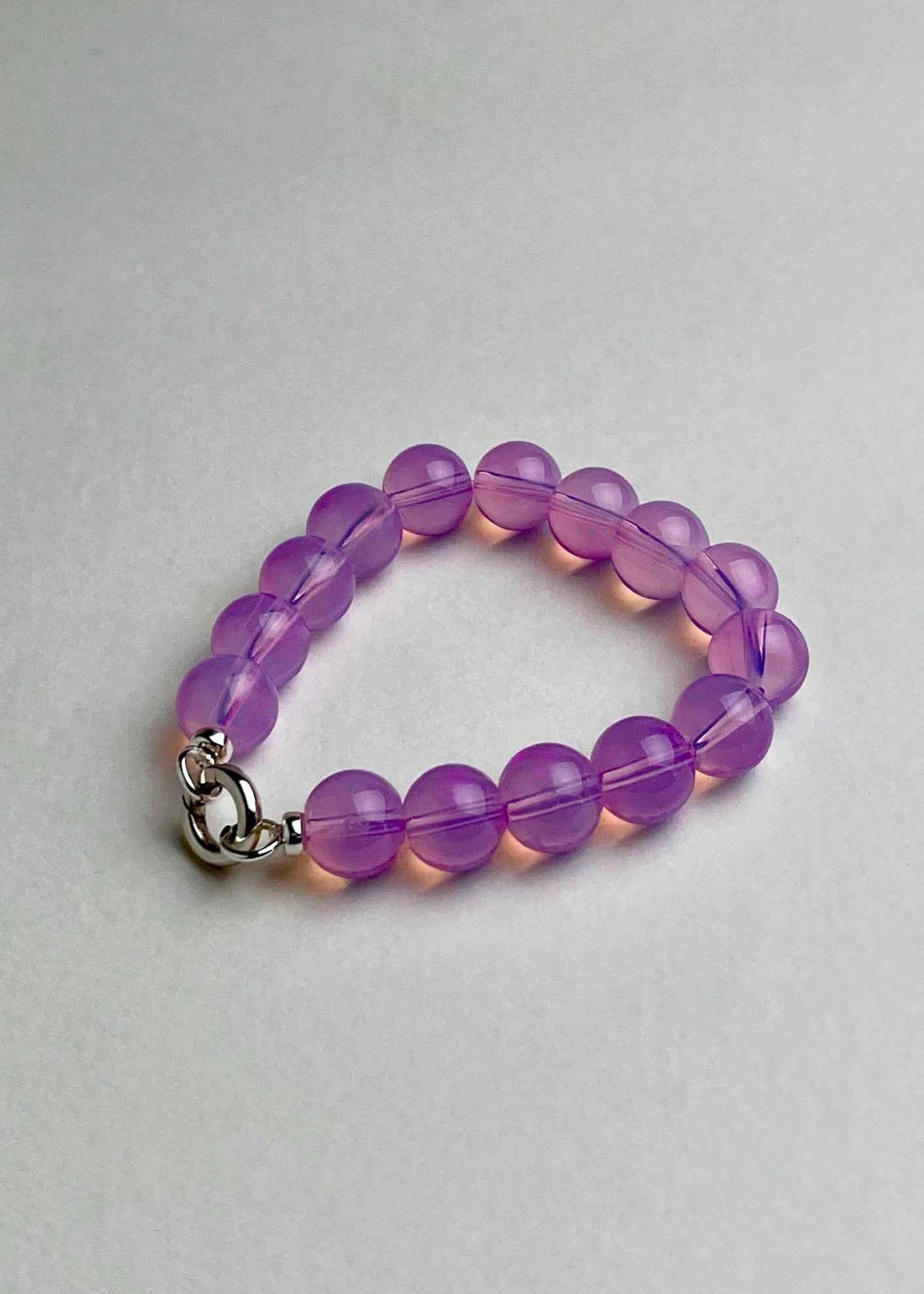 Front view of a deep pink Opalite beaded chainlet with looped Sterling Silver endings closed with connector on a white background