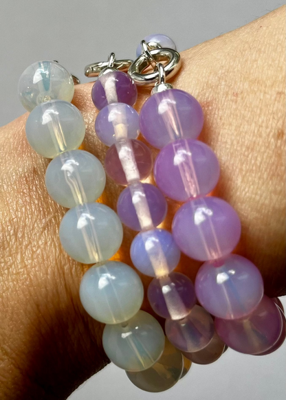 Detail of wrist with bracelet stack of three Opalite beaded chainlets in three different colours