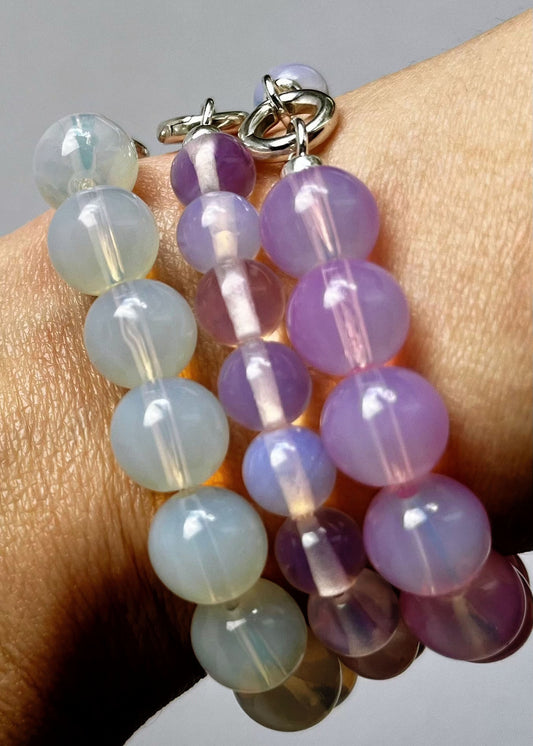 Close up of a there stack of Opalite beaded chainlets in 3 deep pink, peach pink and green blue 