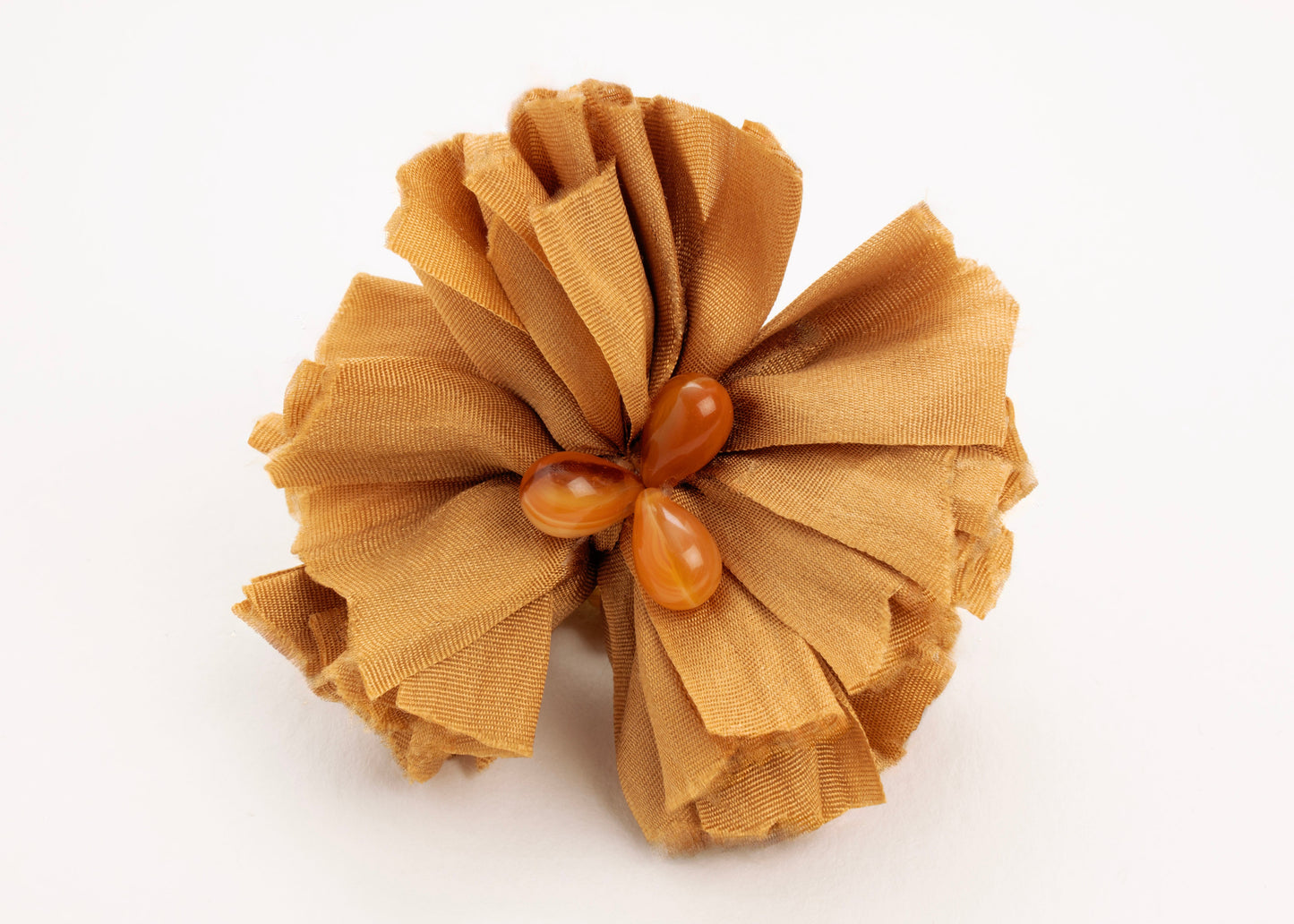 Front view of a gold silk flower charm with glass detail in center on a white background.