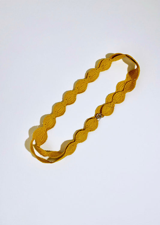 Overhead view of a cotton woven necklace in a double loop with sterling silver endings on a white background