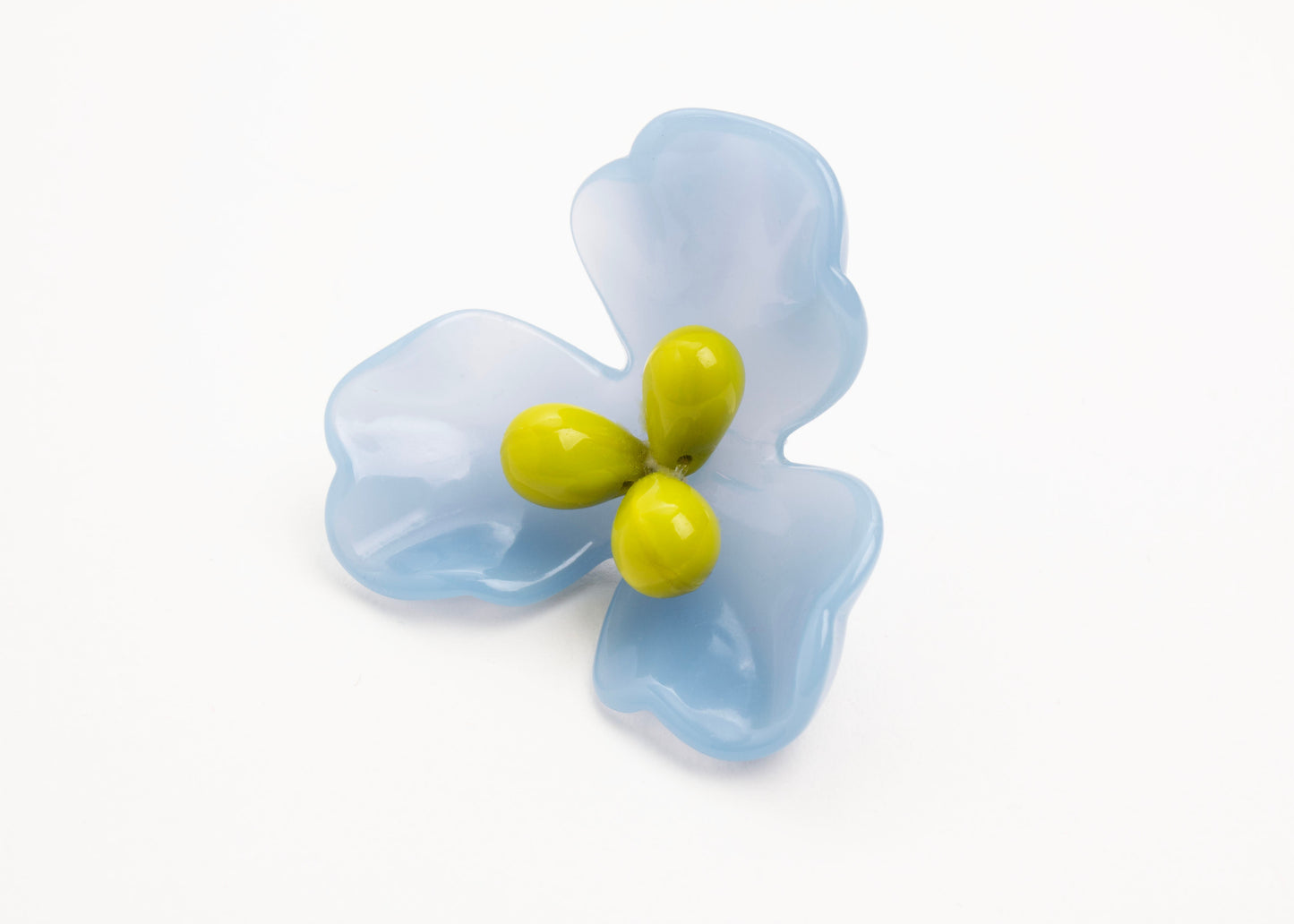 Front view close up of a light blue resin_flower charm with celery green glass bead detail_on a white background