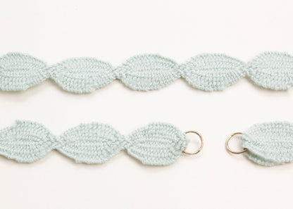 Close up Sterling Silver endings detail of a light green cotton ovals necklace on a white background