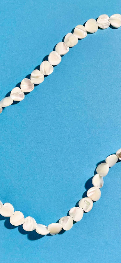Overhead view of MOP heart shaped carved beads necklace strands 