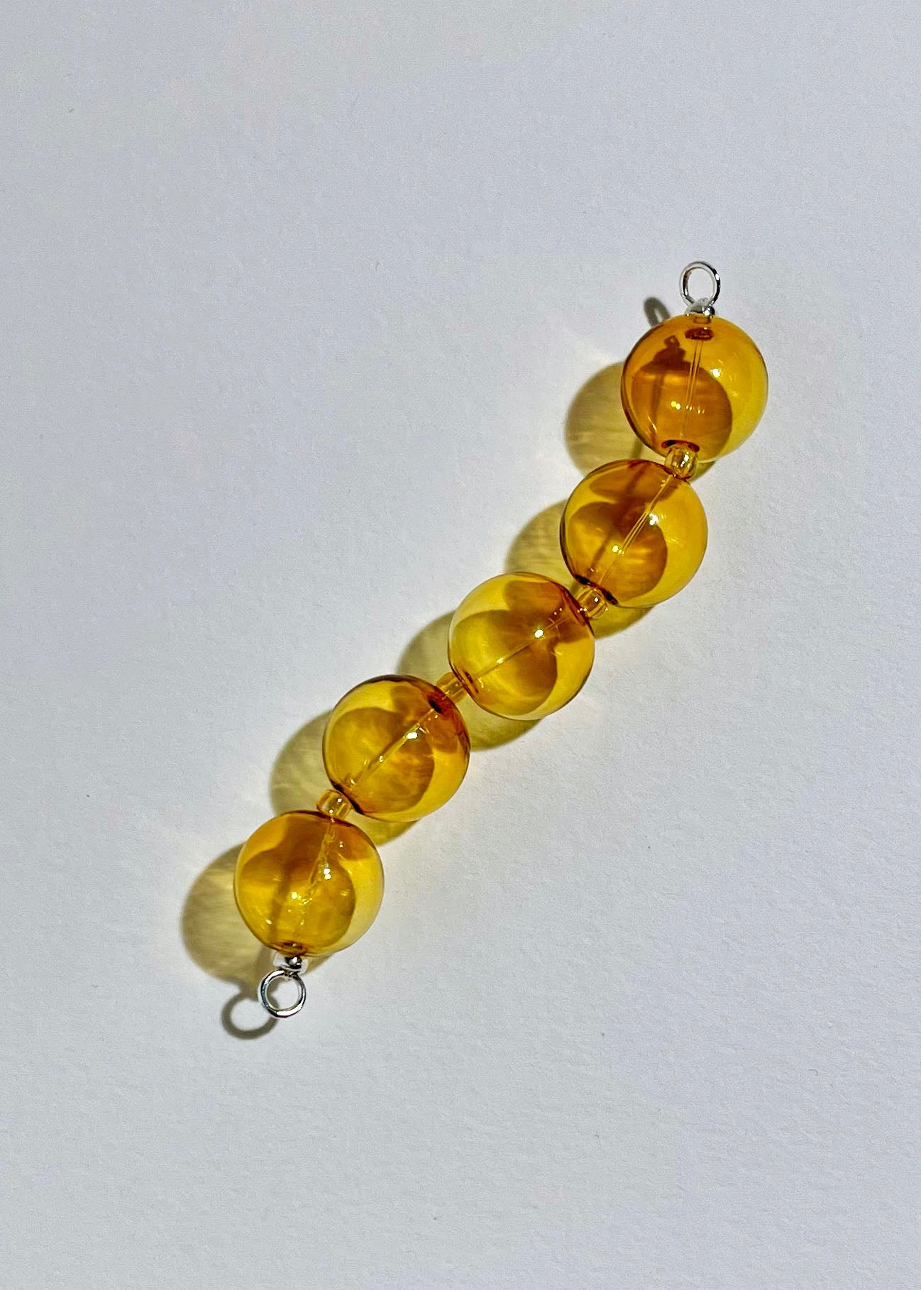Overhead_view_of_yellow_chunky glass bead drop with Sterling Silver endings on a white background