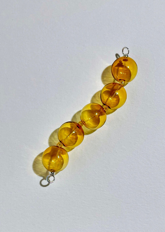Overhead_view_of_yellow_chunky glass bead drop with Sterling Silver endings on a white background