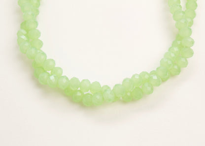 Close up of the drop detail of a mint_green_glass_rondelles_bead_twisted_strand_on a white background