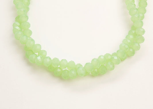 Close up of the drop detail of a mint_green_glass_rondelles_bead_twisted_strand_on a white background