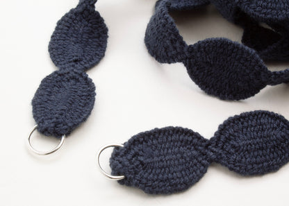 Close up of Sterling Silver looped endings of a light blue cotton woven ovals necklace on a white background. 