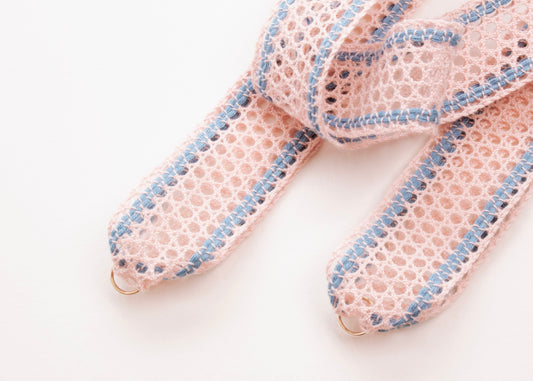 Close up detail of Sterling Silver looped endings of a cotton fishnet ribbon in pink and light blue on a white background