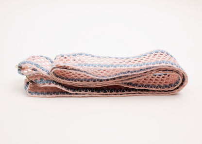 Front side view of a folded cotton fishnet ribbon in pink and light blue with Sterling Silver looped endings on a white background