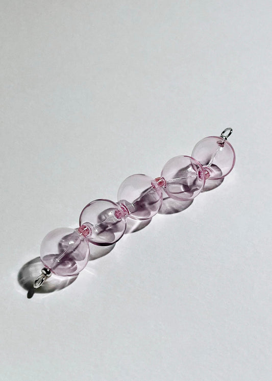 overhead view of a chunky glass bead drop with Sterling Silver endings on a white background