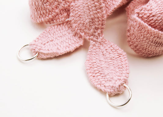 Close up of Sterling Silver looped endings of a pink woven cotton ovals necklace on a white background
