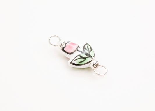 Side diagonal close up of a hand painted pink_porcelain_tulip_charm_on a white background