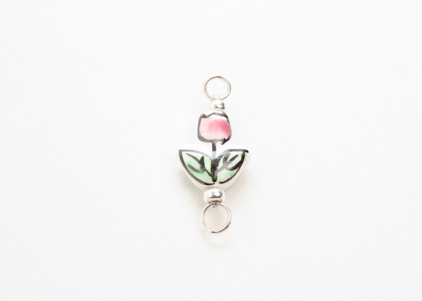 Close up of a hand painted porcelain tulip charm  on a white background