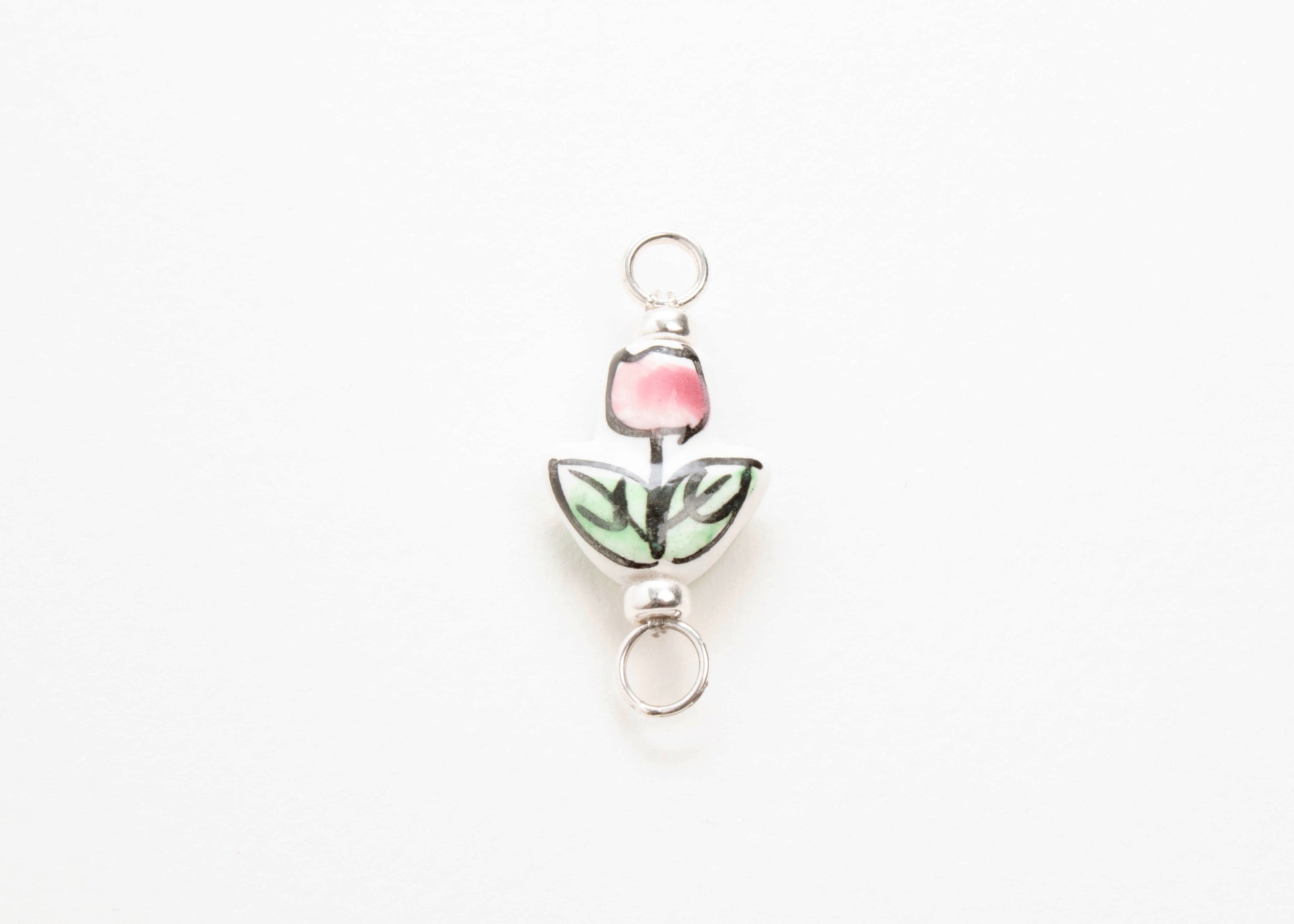 Close up of a hand painted porcelain tulip charm  on a white background