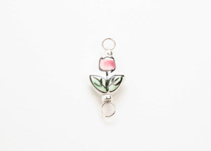 Close up of a hand painted porcelain tulip charm  on a white background