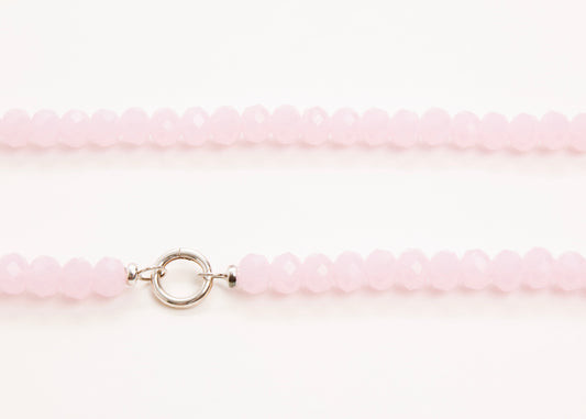 Close-up of a pink glass beaded necklace with a sterling silver clasp on a white background