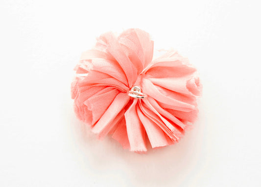 Back view of a pink silk flower charm with sterling silver loop end on a white background.