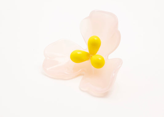 Front side close up of a pink resin_flower charm with yellow glass beads detail_and a Sterling Silver looped ending on a white background.