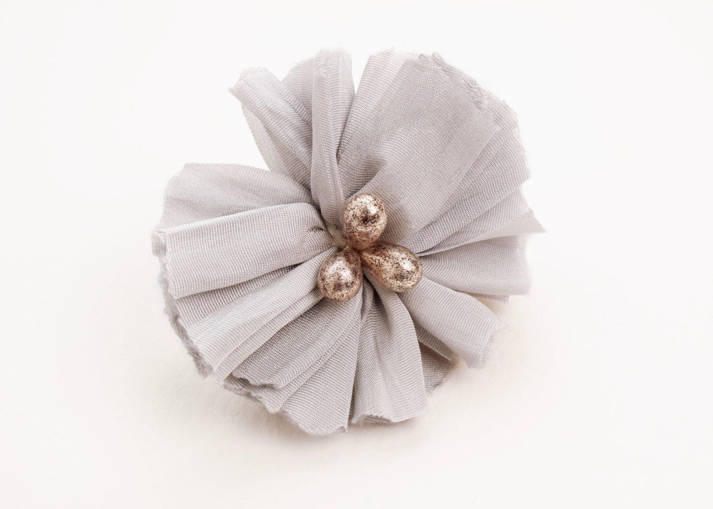 Front view of a silver silk flower charm with glass detail in center on a white background.