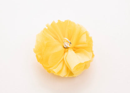 Bright yellow flower connector and charm with pearled white glass bead trio in the centre on a white background.