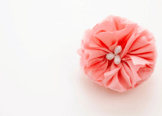 Rich pink flower connector and charm with pearled white glass bead trio in the centre on a white background.