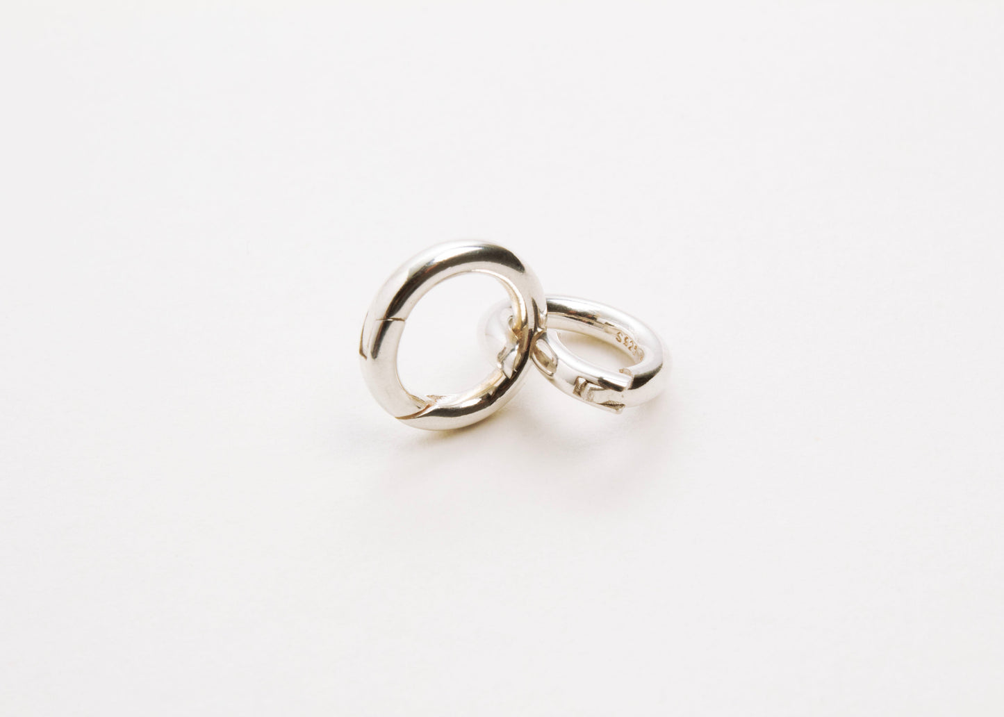 Front view of two Sterling Silver Spring Gate locks one closed and one open on a light grey background
