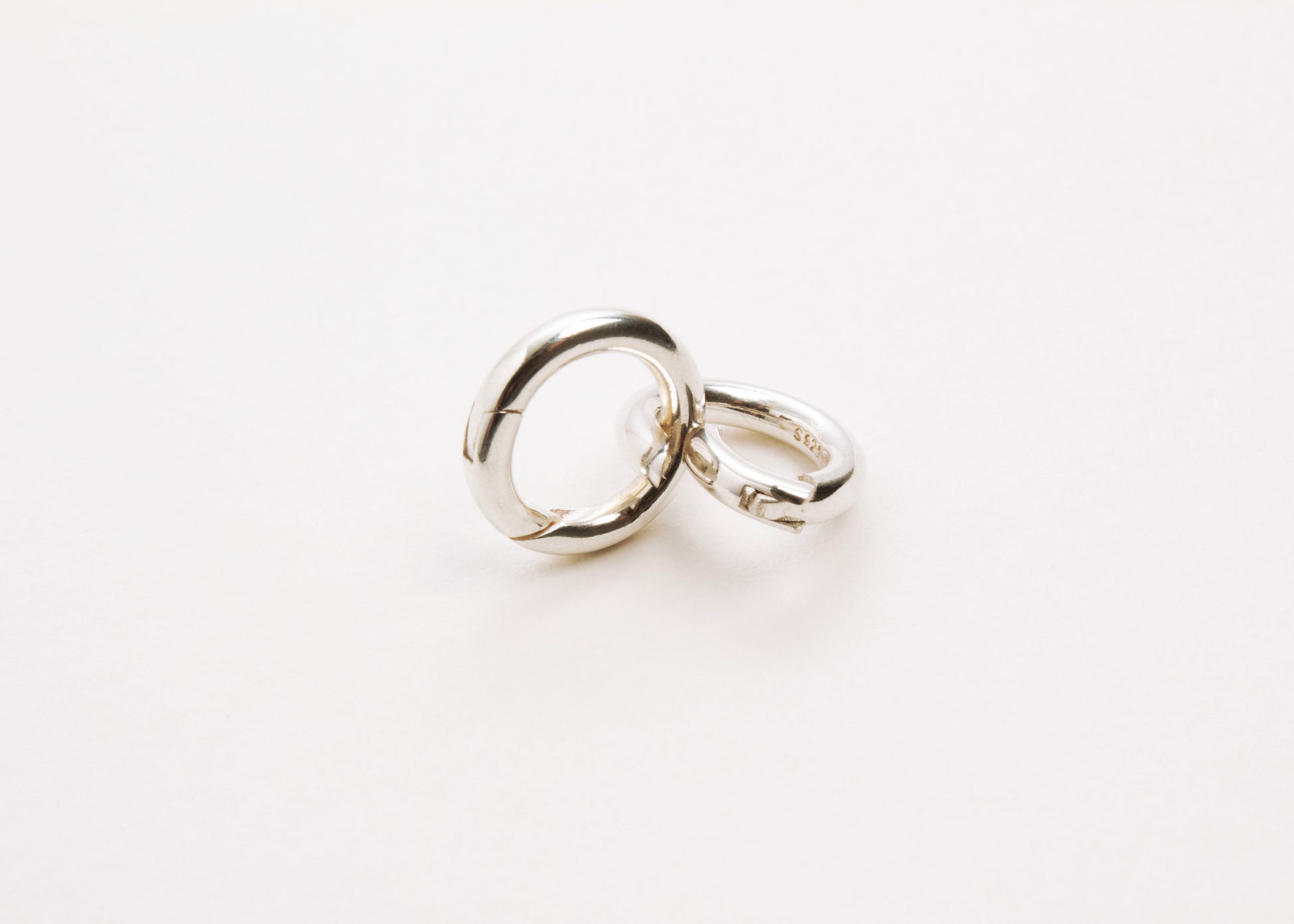Front view of two Sterling Silver Spring Gate locks one closed and one open on a light grey background