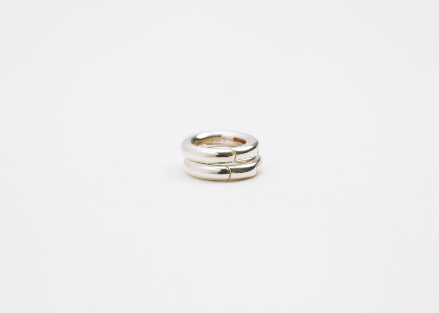 Close up of a tower with two Sterling Silver Spring Gate locks on a light grey background