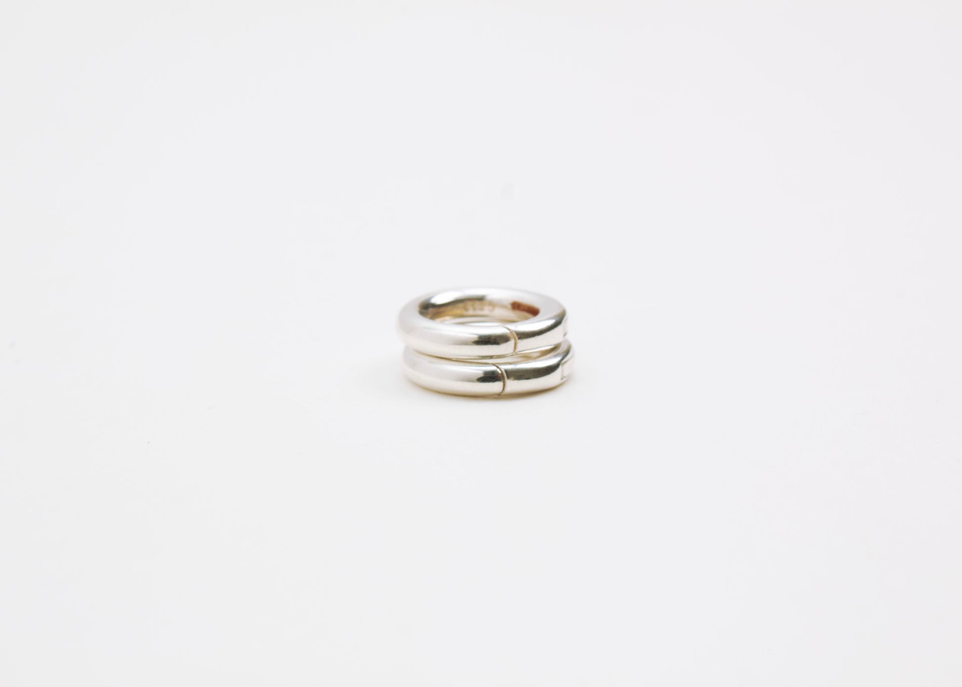 Close up of a tower with two Sterling Silver Spring Gate locks on a light grey background