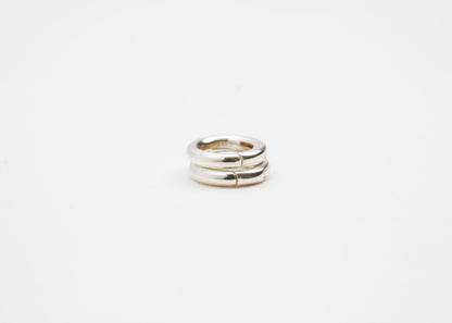 Close up of a tower with two Sterling Silver Spring Gate locks on a light grey background
