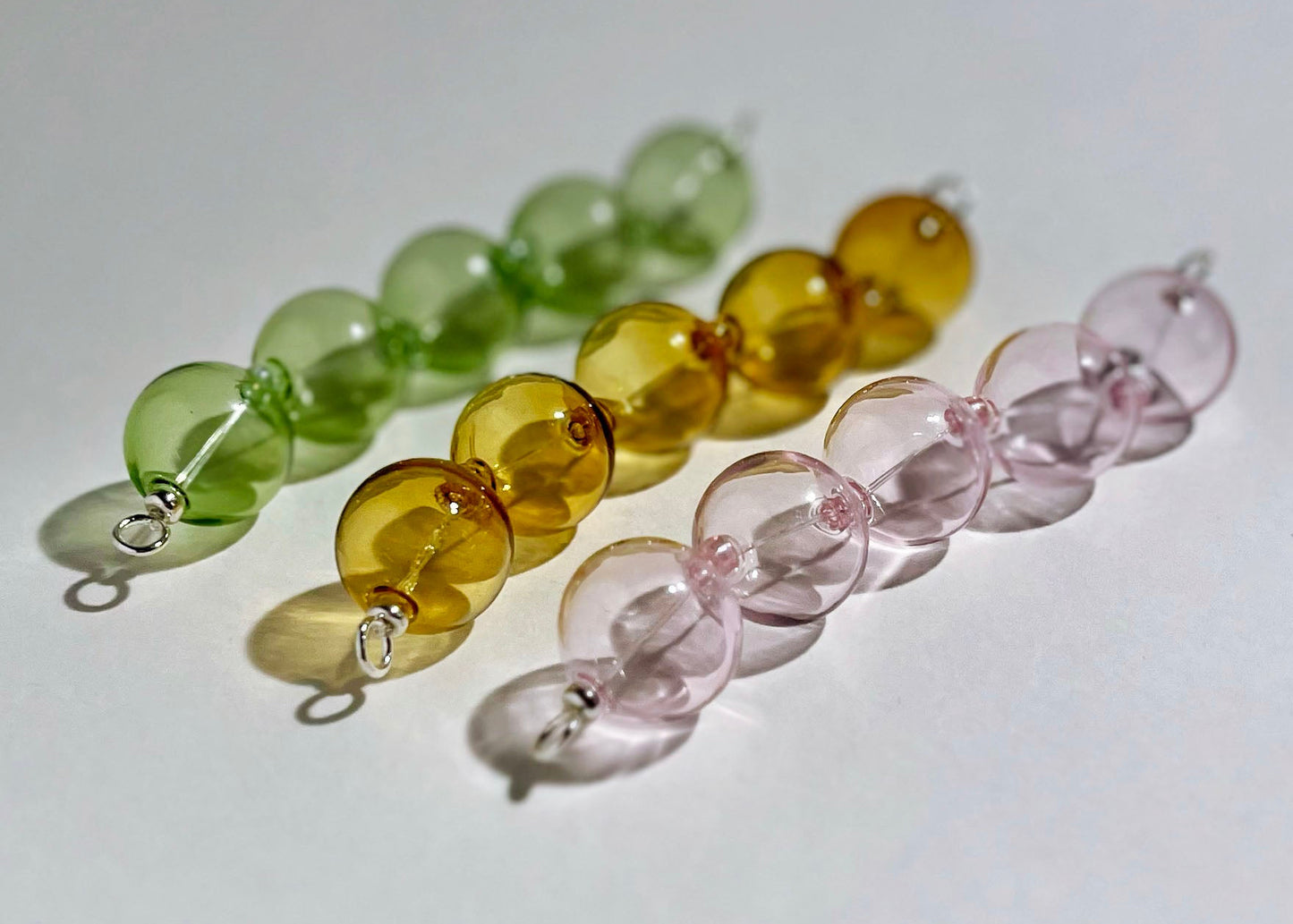 Front view of a trio_of_glass chunky beads chainlet in green, mellow yellow, pink with Sterling Silver endings on a white background