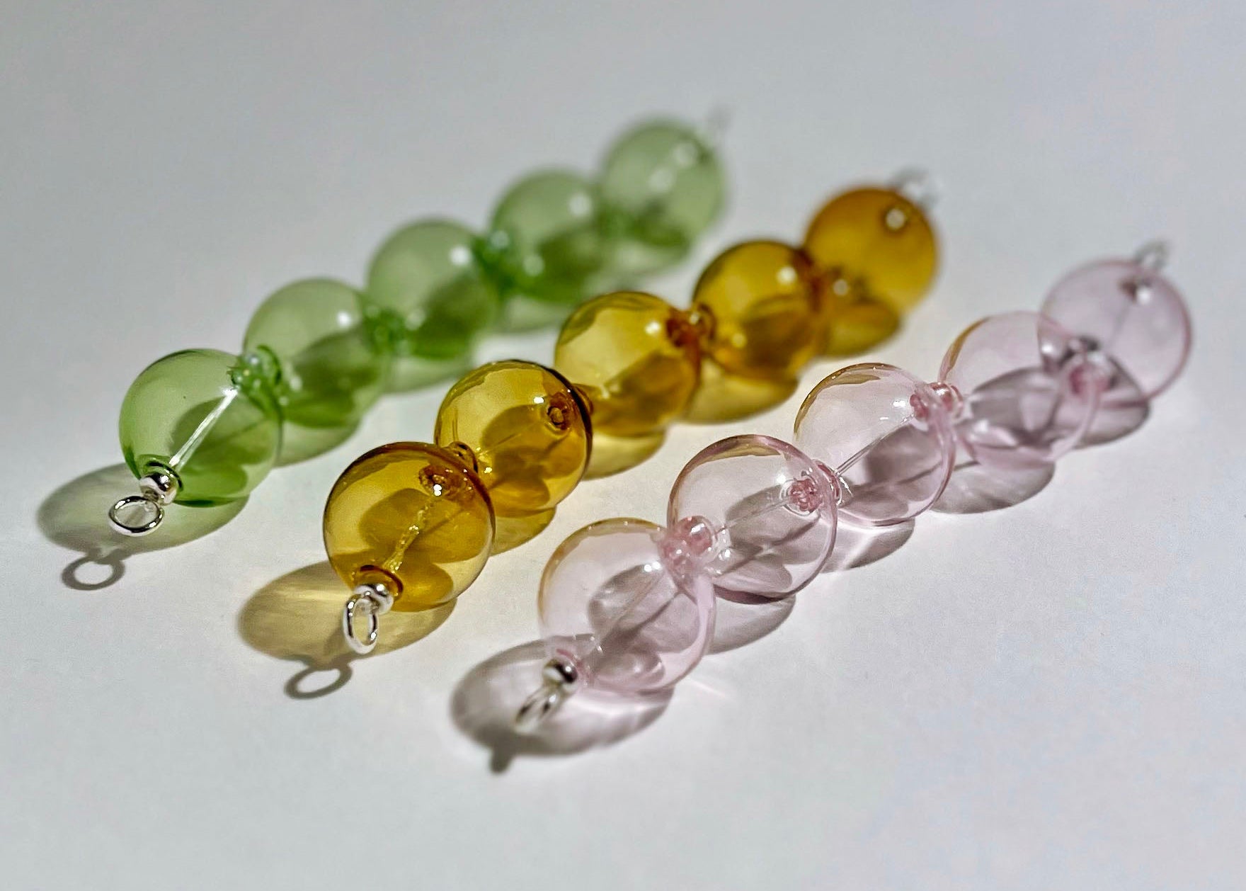 Front view of a trio_of_glass chunky beads chainlet in green, mellow yellow, pink with Sterling Silver endings on a white background