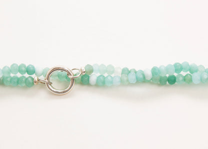 Front horizontal view of the bead detail of a closed turquoise_small_quartzite_beads_strand twisted on a white background