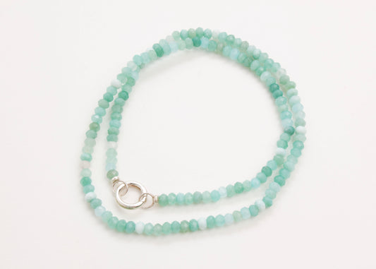 Plan view of a closed turquoise_small_quartzite_bead strand_wrapped_in_two_loops_on a white background