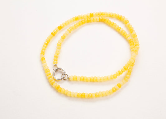 Plan view of a closed yellow_small_quartzite_bead strand_wrapped_in_two_loops_on a white background