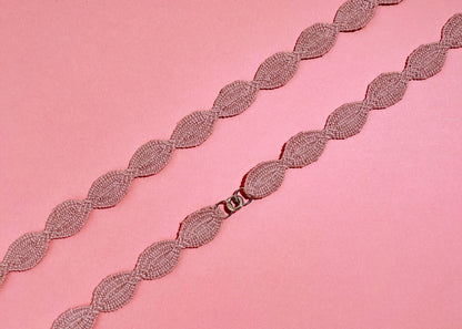 Close view at the fabric and endings detail of a pink cotton interwoven ovals necklace with Sterling Silver endings placed in a double loop 