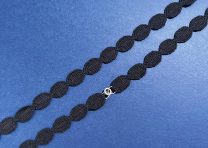 Overhead close look at a navy cotton woven ovals necklace with Sterling Silver endings placed in diagonally on a navy background