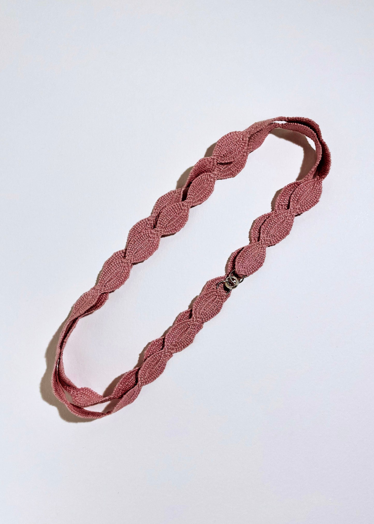 Overhead pink cotton woven ovals necklace with Sterling Silver endings placed in a double loop on a white background